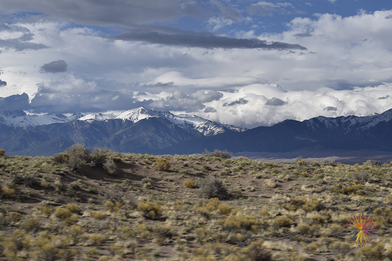 White Capped Mountains towering over the Dunes