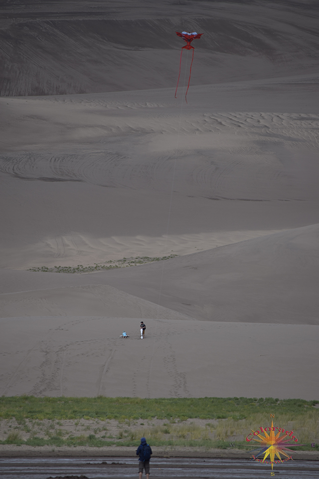 Flying a kite while standing Medano Creek, in Great Sand Dunes National Park, Colorado